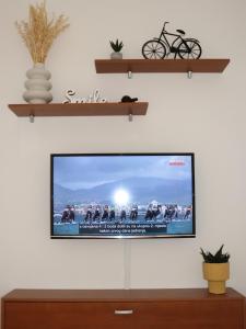 a flat screen tv on a white wall with shelves at Apartment Krk 5294b in Krk