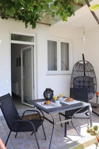 a patio with a table and chairs and a bird cage at Apartment Krk 5294b in Krk