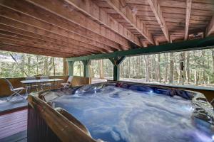 una vasca idromassaggio in una casa nel bosco di ⛰⛵️⛱Mt. Maplewood Lodge❤️Seasonal Specials ☆Poconos☆Cabin☆Hot⛷Tub☆Game Room☆ a Pocono Pines
