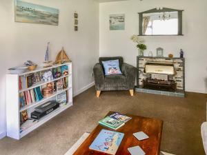 uma sala de estar com uma cadeira e uma lareira em The Hollies em Weston-super-Mare