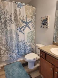 a bathroom with a shower curtain with a toilet and a sink at McDrifty's Getaway in Panama City Beach