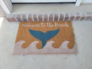 a welcome to the beach welcome mat on a porch at McDrifty's Getaway in Panama City Beach