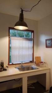 a kitchen counter with a sink and a window at Funky Little Shack in Orick