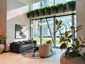 uma sala de estar com um sofá e algumas plantas em City Center Serenity Suite at Southern Cross Precinct em Melbourne