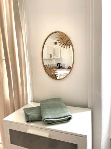 uno specchio sopra un tavolo bianco con un asciugamano verde di La Cornaline a Vesoul