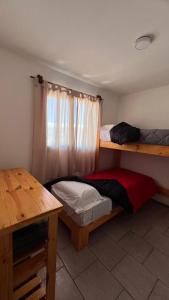 a room with two bunk beds and a table at Las Cabañitas dp2 in San Carlos de Bariloche