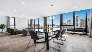 uma sala de jantar com uma mesa e cadeiras numa sala de estar em Luxury Penthouse with Astonishing Bay and City Views em Melbourne