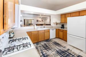 una cocina con electrodomésticos blancos y armarios de madera en Breezing Southwind - monthly special, en Lake Havasu City