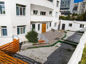 a white house with a orange door and a fence at White hostel Mongolia in Ulaanbaatar