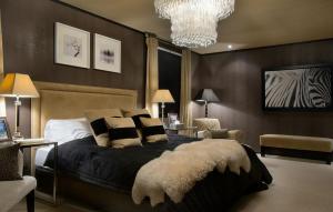 a bedroom with a bed and a chandelier at Hakuba Mountain Lodge in Hakuba