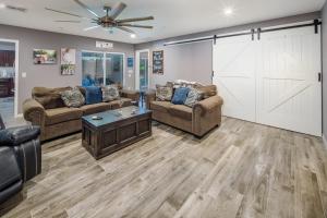 a living room with couches and a sliding barn door at Coral Beauty! Heated Pool & Spa! in Lake Havasu City