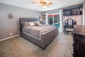 a bedroom with a bed with a ceiling fan at Coral Beauty! Heated Pool & Spa! in Lake Havasu City +15 photos