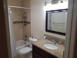 a bathroom with a sink and a toilet and a mirror at Beautiful Spacious 2 Bedroom, 2 Bathroom Condo in Long Beach +30 photos