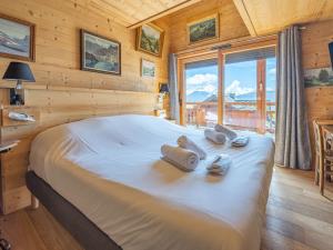 a bedroom with a large bed in a log cabin at Appartement de luxe à l'Alpe d'Huez, sur les pistes, terrasses, parking, 175m² pour 8 personnes - FR-1-645-37 in LʼHuez