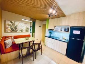 a small kitchen with a table and a refrigerator at Riverview Two Bedroom Condo at One Spatial Iloilo in Iloilo City