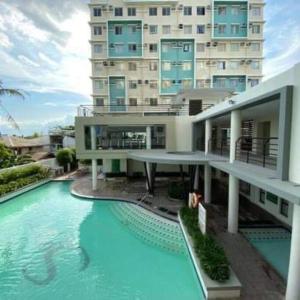 ein Gebäude mit einem Pool vor einem Gebäude in der Unterkunft Riverview Two Bedroom Condo at One Spatial Iloilo in Iloilo City