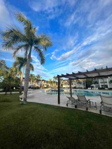 聖斐利－銀港的住宿－Riviera Azul Playa Dorada，游泳池旁的棕榈树