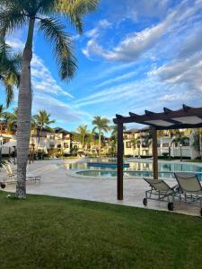 a resort with a pool and a palm tree at Riviera Azul Playa Dorada in San Felipe de Puerto Plata