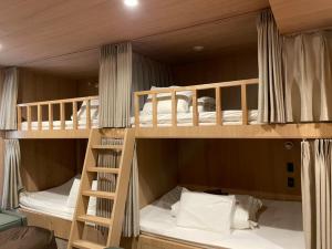 two bunk beds in a room with a ladder at THE BONDS HOTEL TOKYO in Tokyo