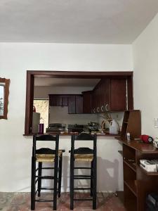a kitchen with two bar stools in a room at Amalia's House in Los Manaderos