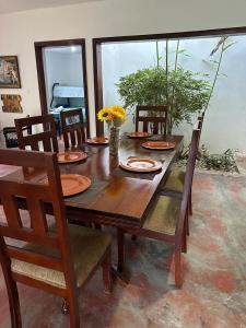 drewniany stół i krzesła z płytkami i kwiatami w obiekcie Amalia's House w mieście Los Manaderos