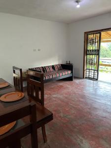 un soggiorno con divano, tavolo e sedie di Amalia's House a Los Manaderos