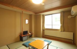 a living room with a table and a window at Hotel Chalet Ryuo in Yamanouchi