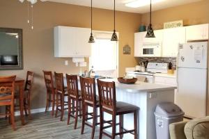 a kitchen with white cabinets and a table and chairs at McDrifty's Hideaway in Panama City Beach