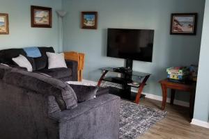 a living room with two couches and a flat screen tv at McDrifty's Hideaway in Panama City Beach