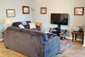 uma sala de estar com um sofá e uma televisão de ecrã plano em McDrifty's Hideaway em Panama City Beach