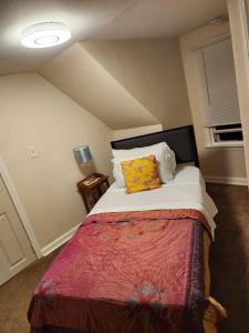 1 dormitorio con 1 cama con manta roja y almohadas amarillas en Cozy cute Relaxing home, en Southbury