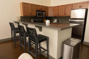 eine Küche mit einer Theke mit Stühlen und einem Kühlschrank in der Unterkunft Stylish And New 1 Br Loft Apartment Right Downtown in Roanoke