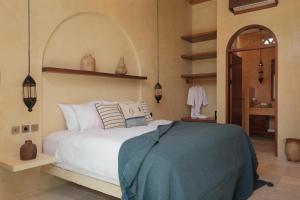 a bedroom with a large white bed and a mirror at Lina Boutique Villas and Spa in Kuta Lombok