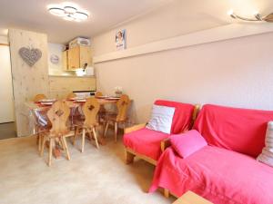 a living room with a red couch and a table at Les Gets - Appart cosy avec mezzanine et parking, proche pistes - FR-1-623-145 in Les Gets