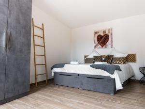 een slaapkamer met een bed en een houten vloer bij Gîte Thann, 4 pièces, 5 personnes - FR-1-744-11 in Thann