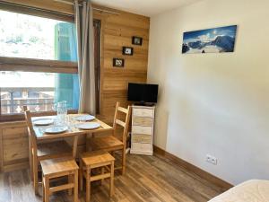 une salle à manger avec une table, des chaises et une télévision dans l'établissement Studio Les Gets, 1 pièce, 4 personnes - FR-1-623-231, aux Gets