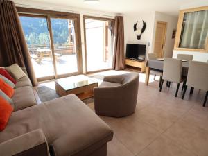 ein Wohnzimmer mit einem Sofa und einem Tisch in der Unterkunft Appartement Les Gets, 3 pièces, 6 personnes - FR-1-623-32 in Les Gets