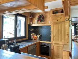 a kitchen with wooden cabinets and a counter top at Appartement Les Gets, 2 pièces, 4 personnes - FR-1-623-256 in Les Gets