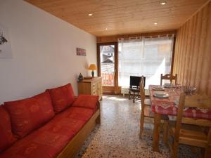 - un salon avec un canapé rouge et une table dans l'établissement Appartement Les Gets, 2 pièces, 4 personnes - FR-1-623-185, aux Gets