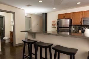 eine Küche mit zwei Barhockern und einer Arbeitsplatte in der Unterkunft Luxury 2 Bedroom Apt With Exposed Brick Downtown in Roanoke