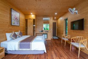 ein Schlafzimmer mit einem Bett und einem TV in einem Zimmer in der Unterkunft Suối Ngọc Retreat Venuestay in Hanoi