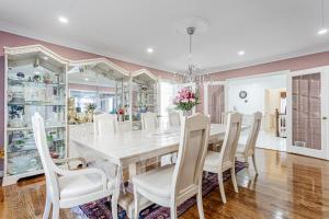 une salle à manger avec une table et des chaises blanches dans l'établissement Luxurious Spacious Dream Home, à Colline De Richmond