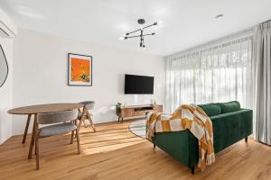 a living room with a green couch and a table at Peppertree Apartments in Sale