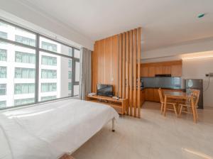 芽莊的住宿－Muong Thanh Vien Trieu Nha Trang Apartment - Review Nha Trang，一间卧室配有一张床铺和一张桌子,还设有一间厨房