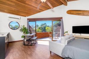 a bedroom with a bed and a living room at Aquarius Backpackers Resort in Byron Bay