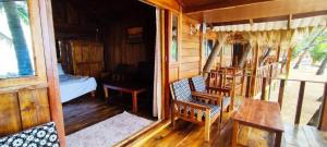 Habitación con porche, cama y mesa. en Sea Front Cottage Little Khola en Cola