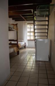a room with a white refrigerator and a window at Pousada Casa da Pedra in Búzios