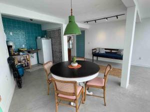 - une cuisine et une salle à manger avec une table et des chaises dans l'établissement Loft dentro da comunidade Solar do unhão salvador, à Salvador