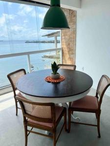 - une table à manger avec des chaises et une plante en pot dans l'établissement Loft dentro da comunidade Solar do unhão salvador, à Salvador