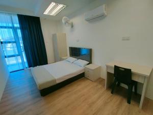 Habitación de hotel con cama, escritorio y escritorio. en Agape Hostel, en Sibu